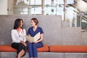 Two female healthcare workers discussing